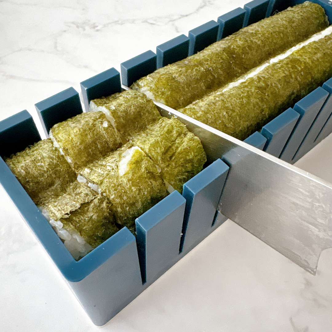 寿司ロールカッターで海苔巻きを均等にカットしている様子。