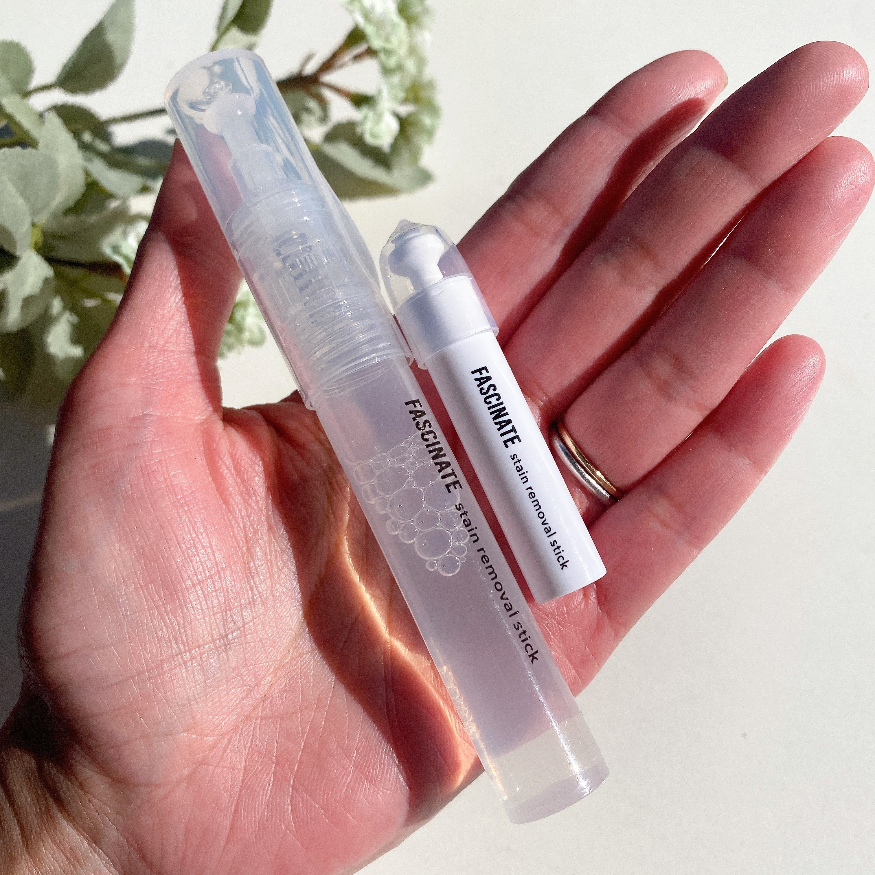 手のひらに美容製品のスティック2本。一本はロールオン、もう一本はスティックタイプ。ブランド名は「FASCINATE」。