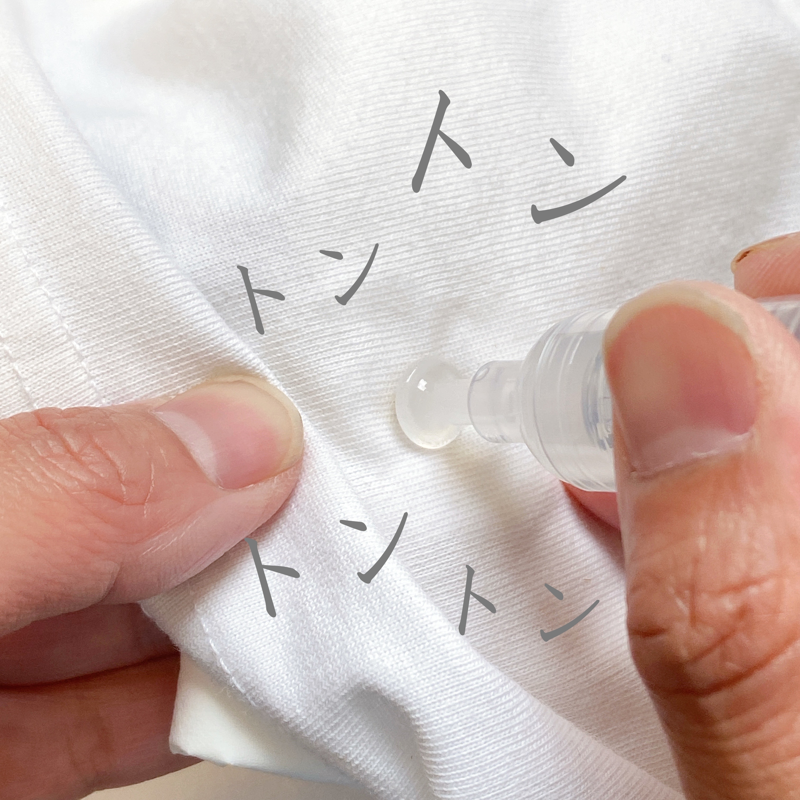 白い布に液体を塗布する手元の様子。周囲に「トントン」との文字が書かれている。