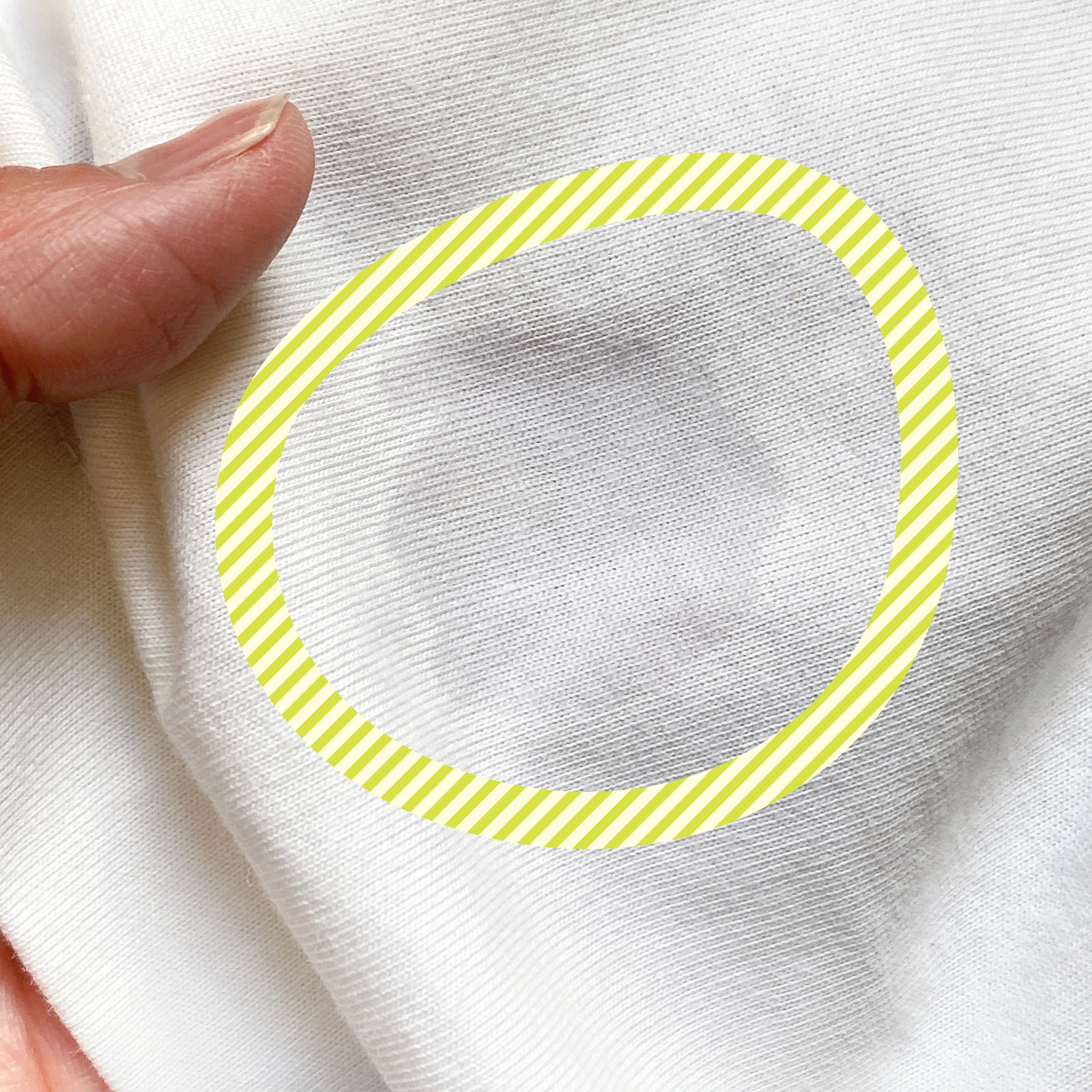 手で握られた布に丸で囲まれた薄いシミがある。