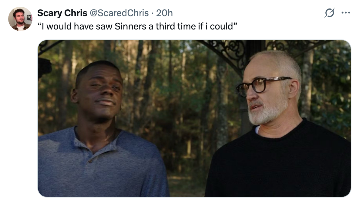 Two men stand outdoors. One, wearing a casual shirt, looks skeptical. The other, in glasses and a dark sweater, gazes intently at him