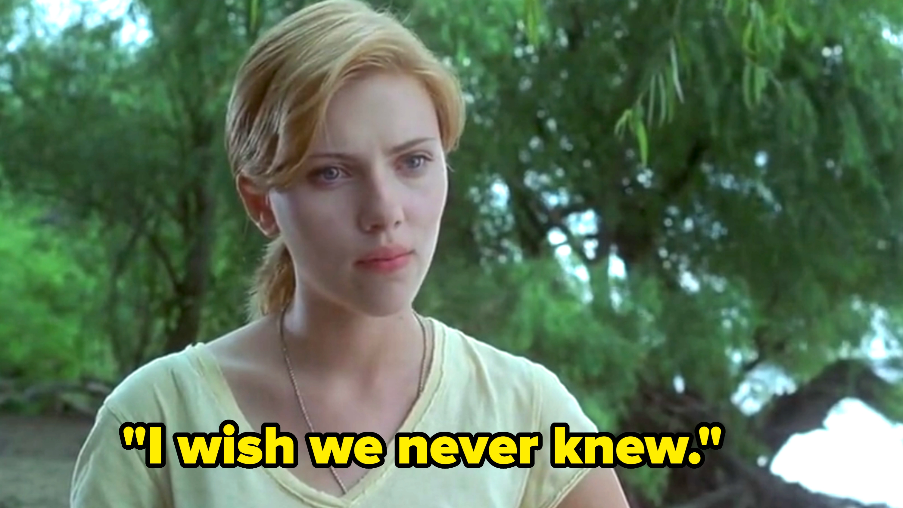 Person outdoors, wearing a casual T-shirt, with thoughtful expression amidst trees and greenery