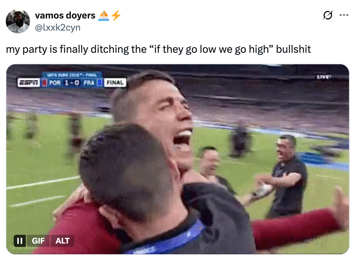 Soccer player celebrating passionately on the field with teammates during a match, surrounded by a cheering crowd