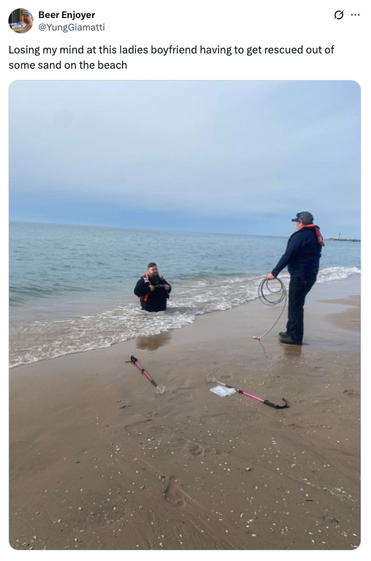 Person stuck in sand at the beach being rescued by someone holding a rope, with a caption expressing amusement at the situation