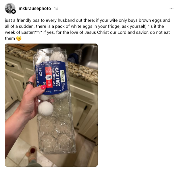 A hand holding a carton of white eggs above an open fridge. Caption humorously advises checking if it's Easter before eating them