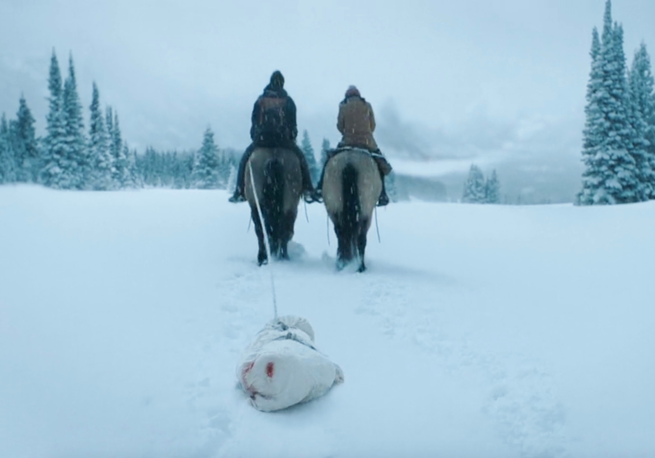 Dina, Ellie, and Jesse riding horses while they drag Joel's body, which is wrapped in a sheet