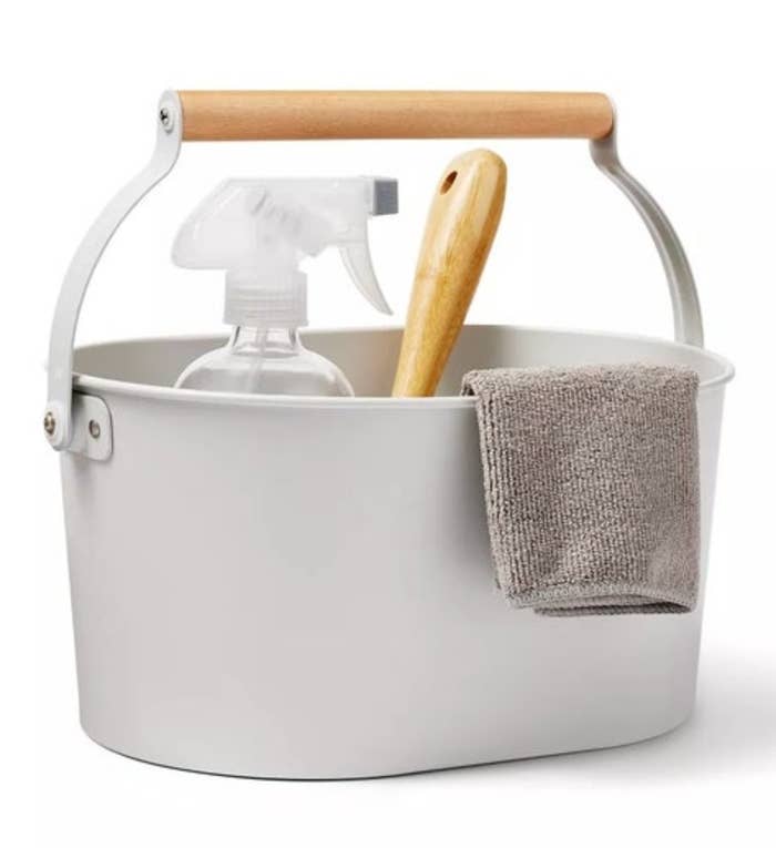 Cleaning kit with a spray bottle, brush, and cloth successful a achromatic bucket with a woody grip connected a achromatic background
