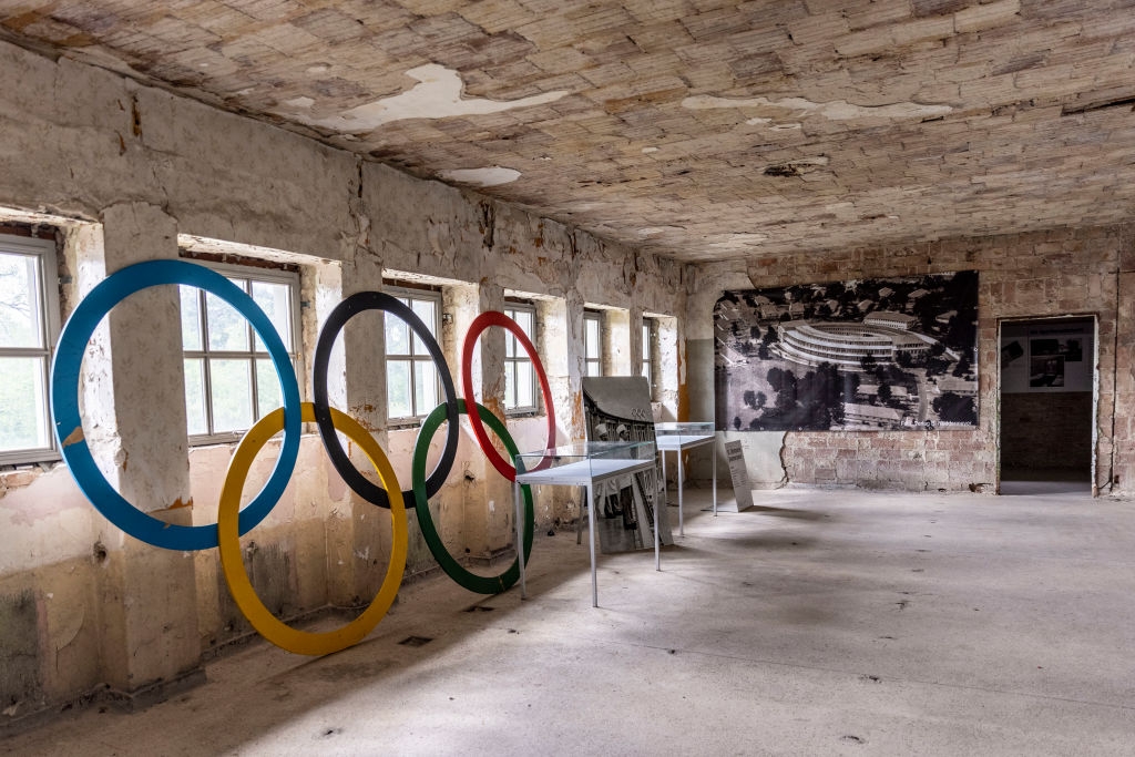 Room with Olympic rings, peeling walls, and sparse furniture