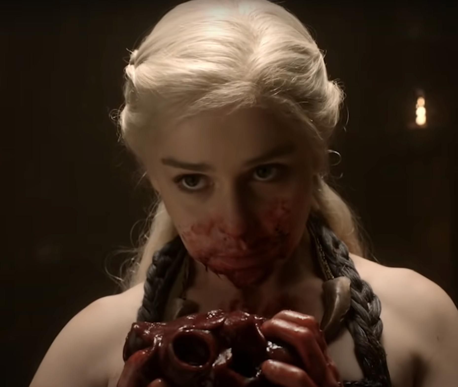 Daenerys with her face and hands covered in blood, holding the heart