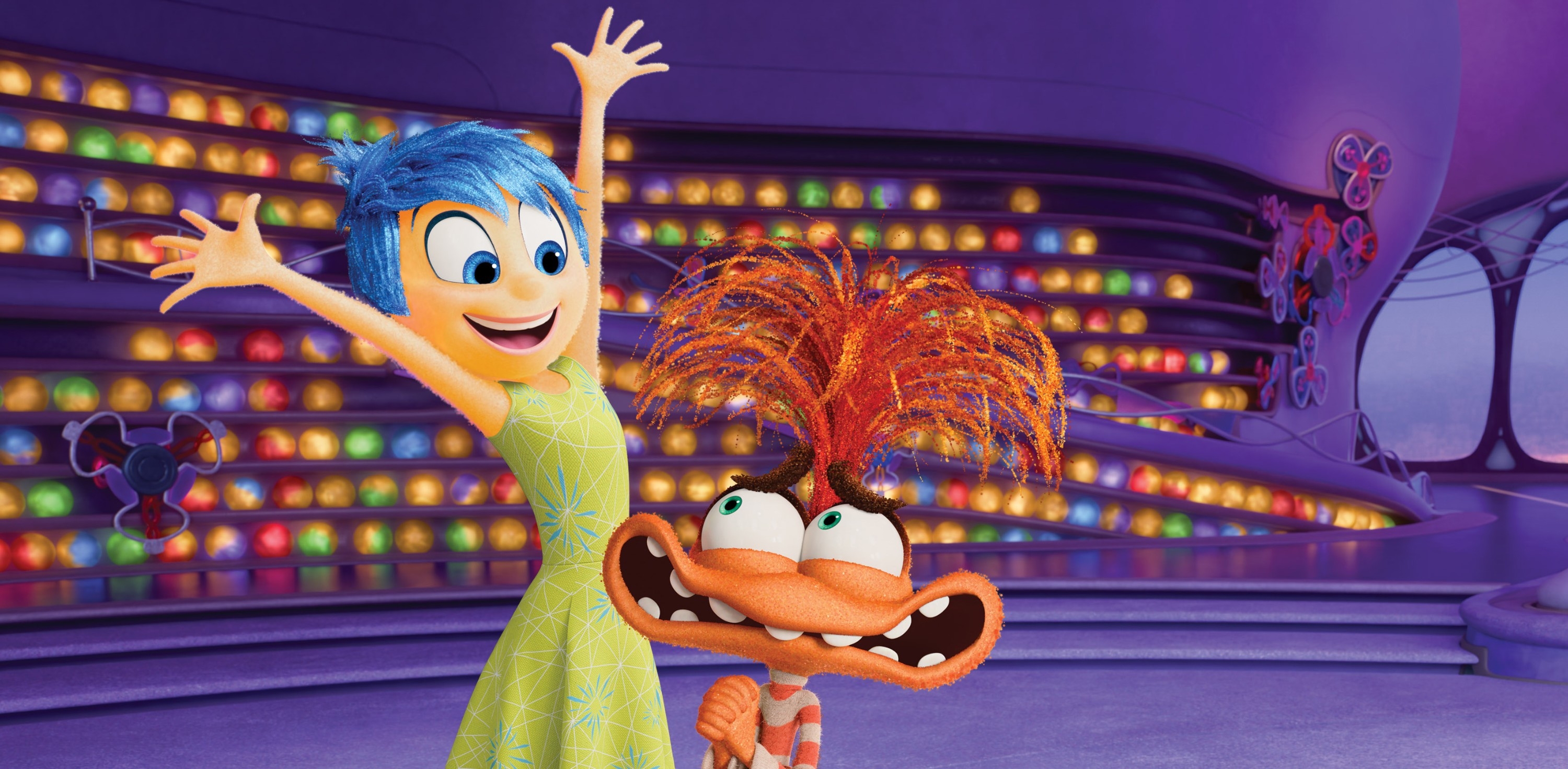Inside Out 2 characters, Joy with blue hair in a dress, and Fear with wild orange hair, display excitement in a colorful, circular room