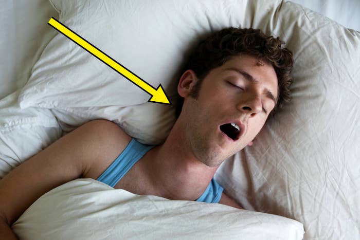 Person snoring while sleeping on a pillow with mouth slightly open