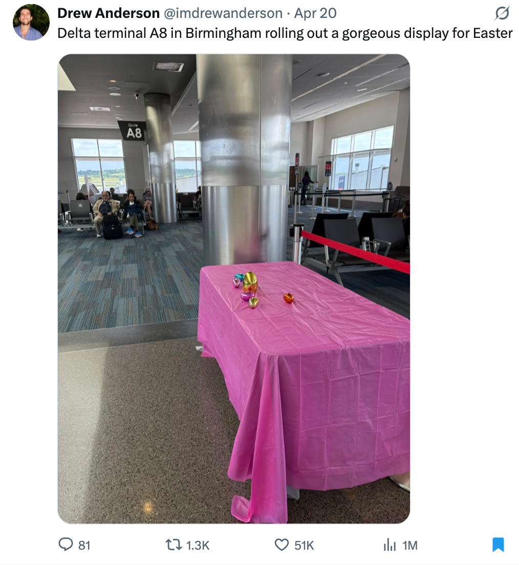 Airport terminal display with a pink tablecloth and a few scattered Easter eggs next to gate A8