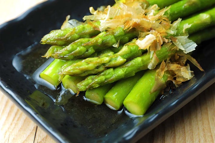 皿に盛られたアスパラガスに鰹節が振りかけられた料理。