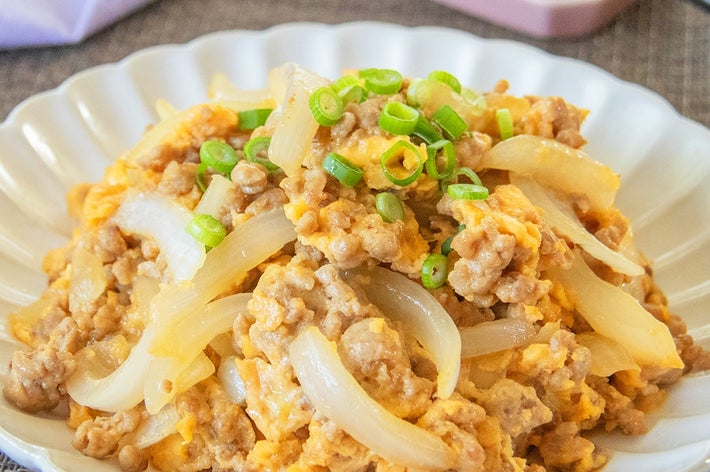 お皿に盛られた新玉ねぎとひき肉と卵の炒め物。小ネギがトッピングされている。