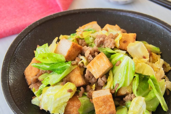 厚揚げとキャベツ、豚ひき肉の炒め物が黒い皿に盛り付けられている。