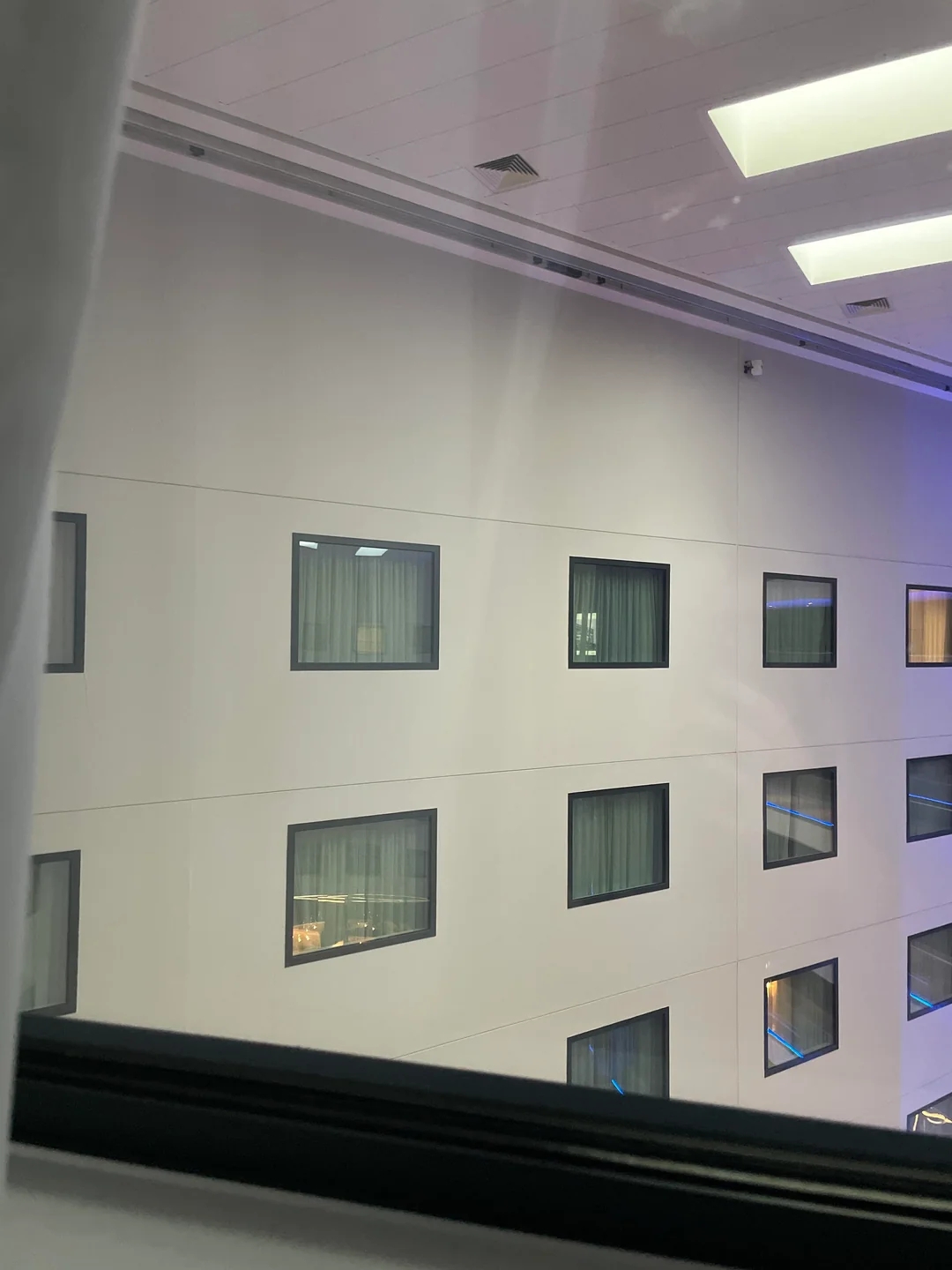 View from a window showing a building's interior wall with several windows visible