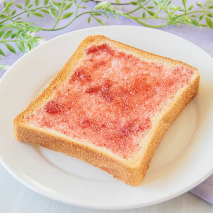 皿にのったトーストがイチゴジャムで塗られた状態。