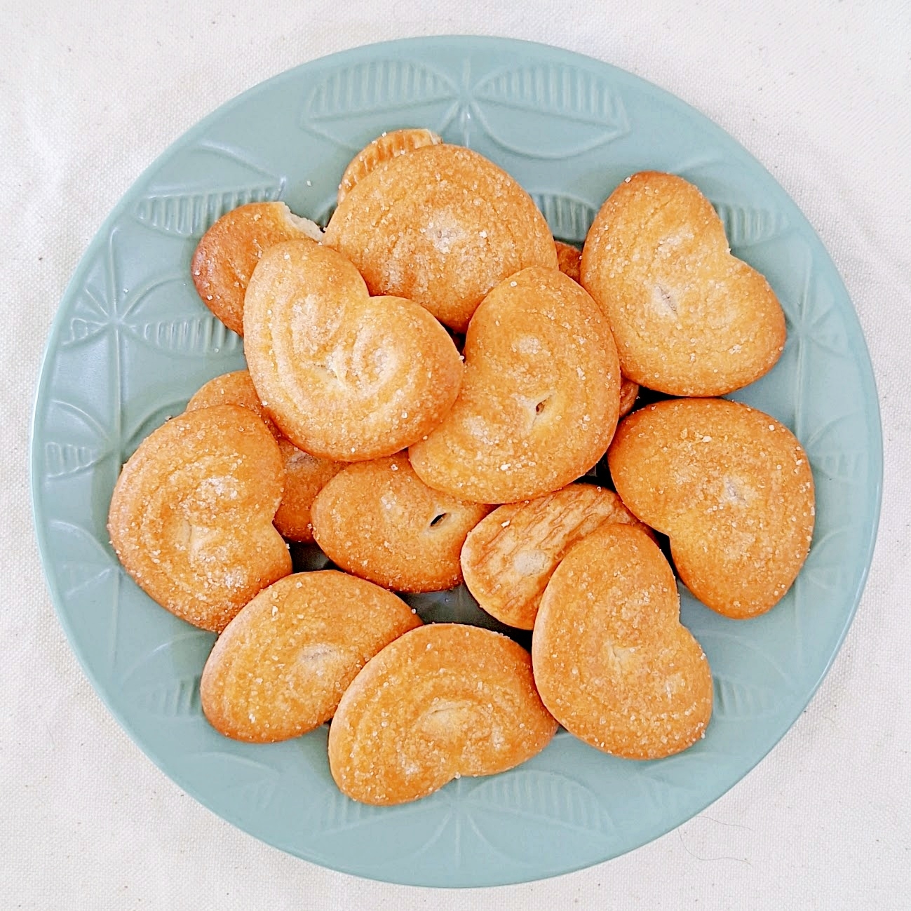 ハート型のクッキーが青い模様付きの皿に盛られている。