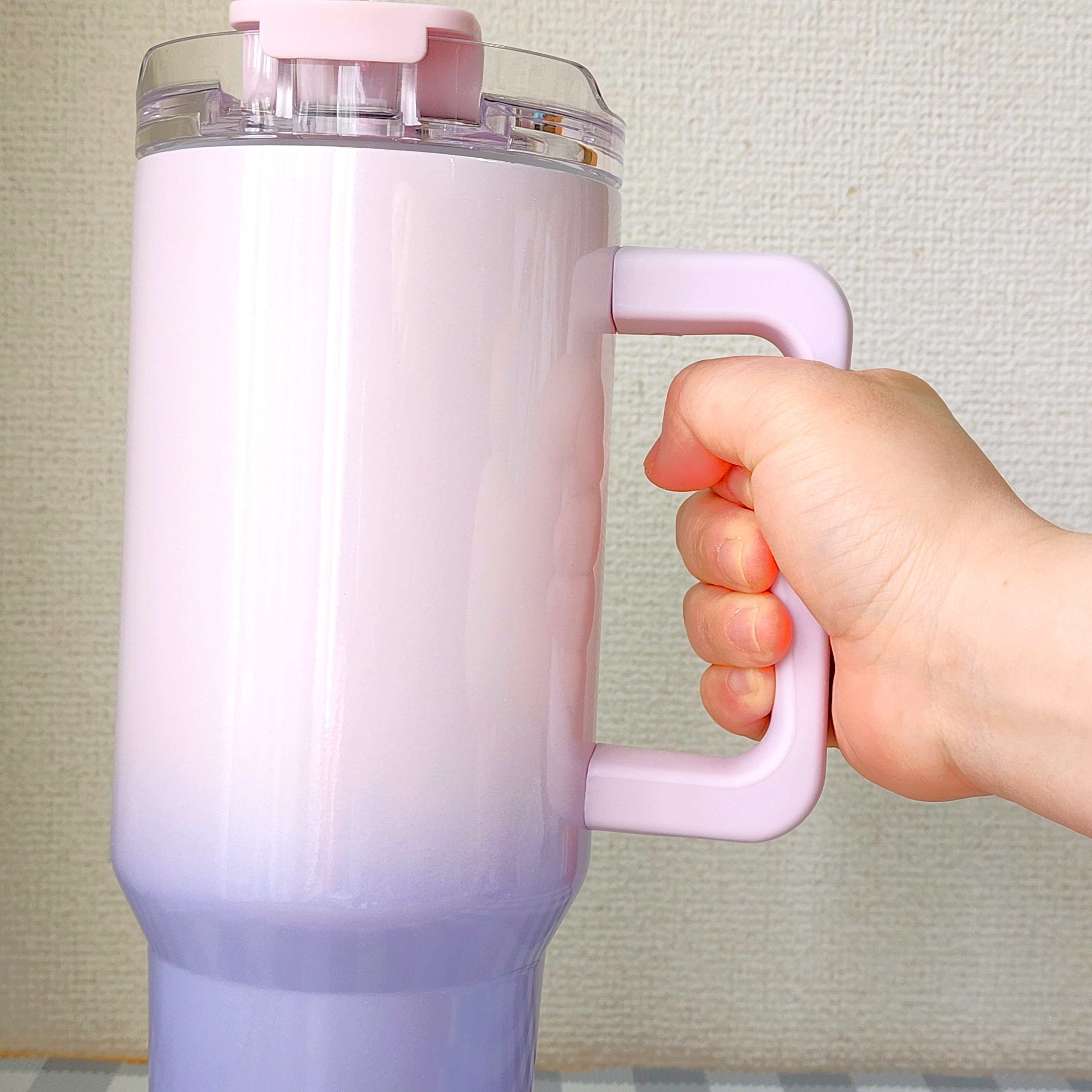 人の手が大きな取っ手付きのカップを持っている様子。