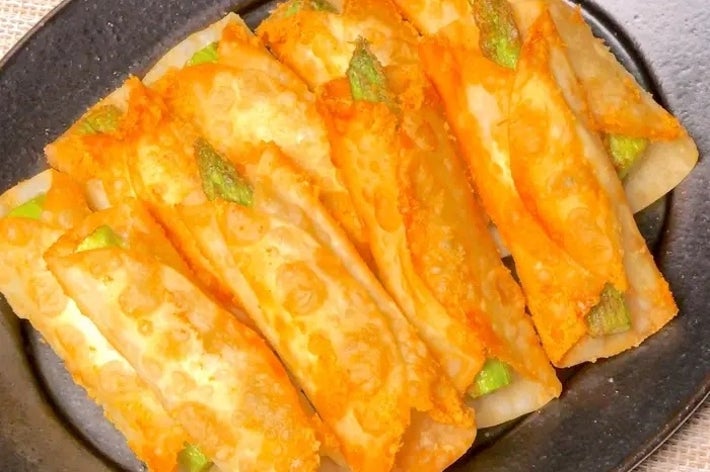 皿に盛られた揚げ春巻き。端がこんがり焼き色で、緑色の具材がちらりと見える。