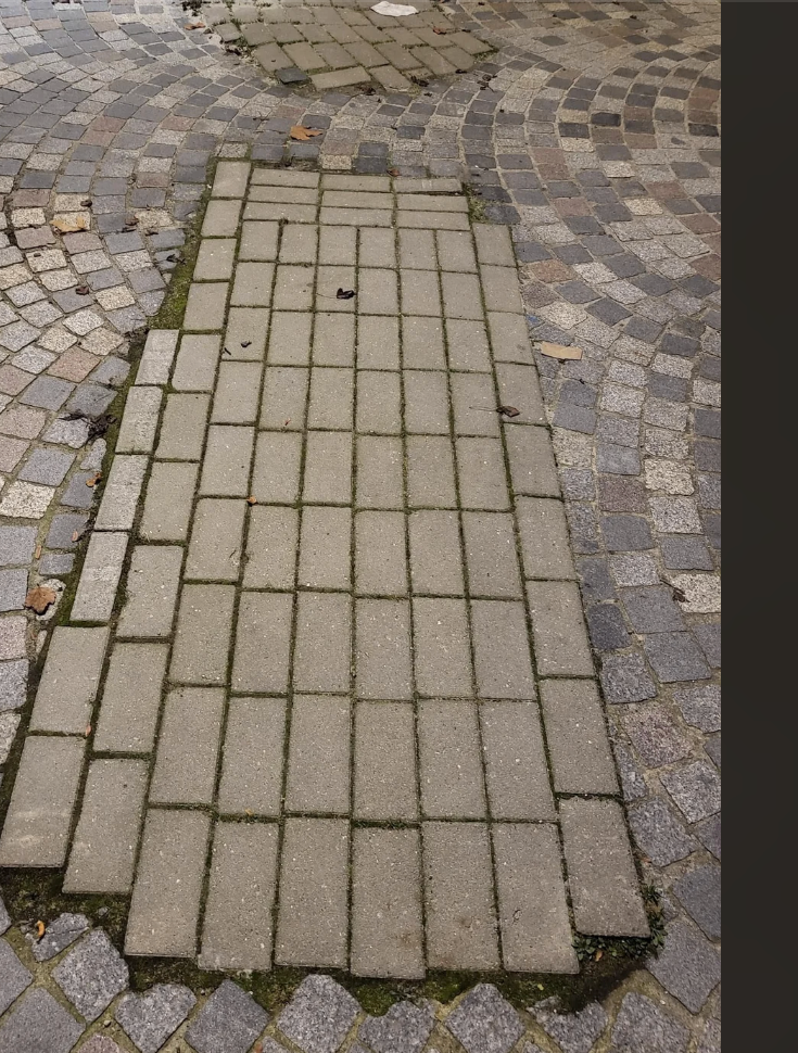 Uneven pavement section filled with mismatched bricks in a pattern; caption highlights utility company's unconventional repair job