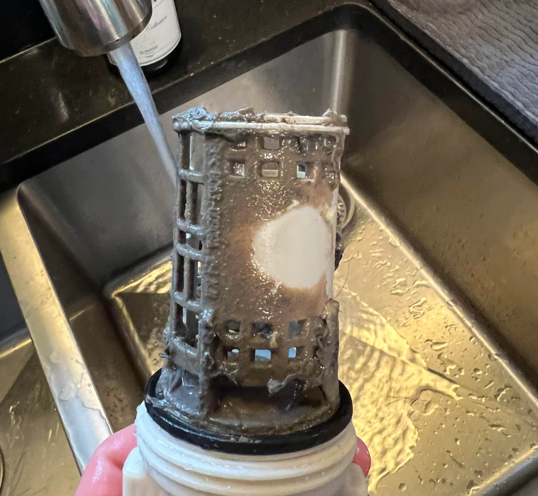 Screenshot of a Reddit post titled "Reminder: clean your floor food washing machine." Image shows a filter from a food washing machine under a sink faucet