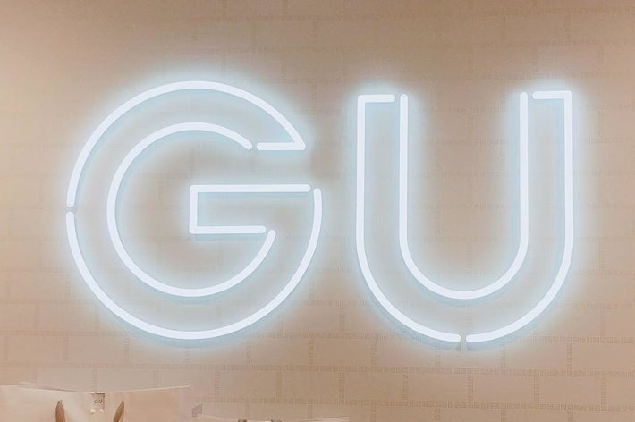 壁にネオンで「GU」と書かれたサイン。
