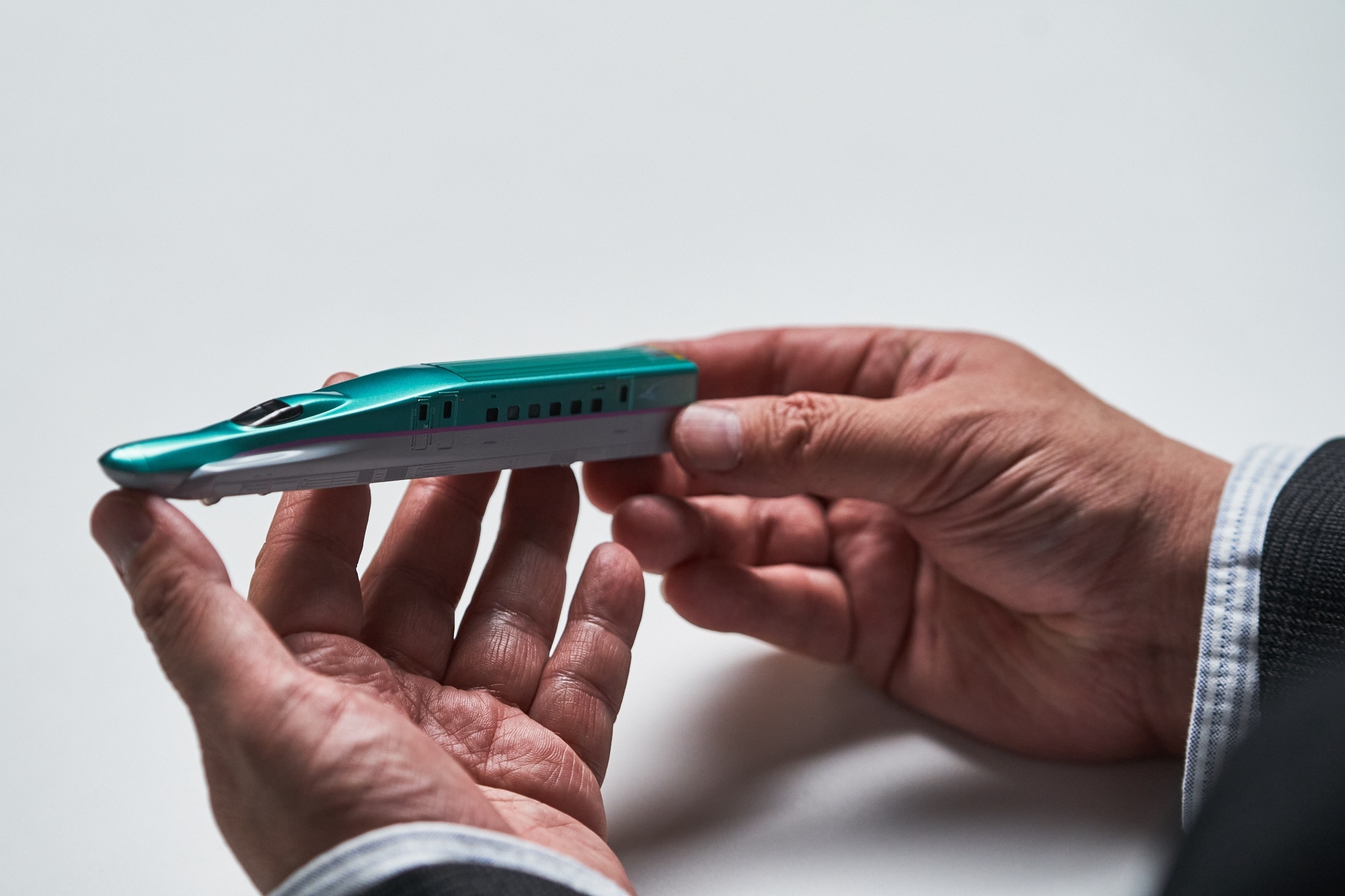 新幹線の模型を手に取る樋口監督 (撮影:黒羽政士)