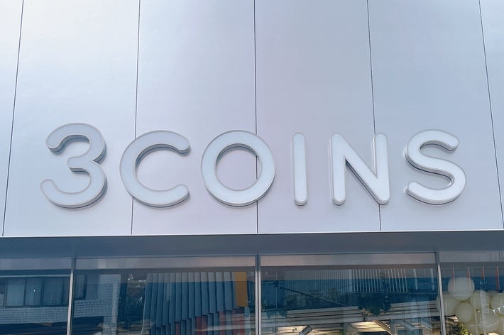 ショップ「3COINS」の看板。表示・装飾品が店頭に並び、カフェを連想させるイメージもある。