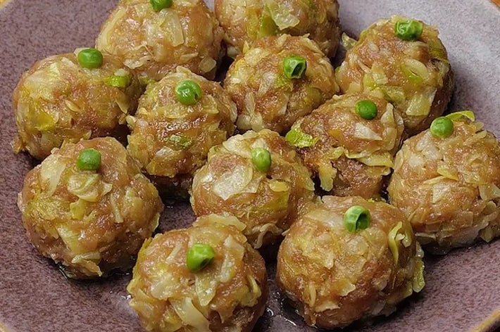 お皿に盛られた肉団子の料理。上には緑の豆が飾られている。