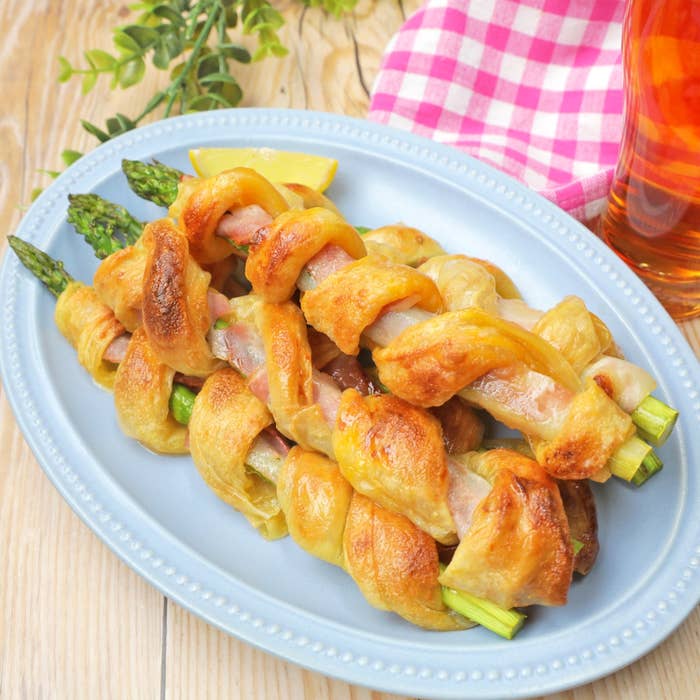 アスパラガスとハムのパイ巻き、皿に盛り付けられた料理。ピクニックや軽食に最適な一品。