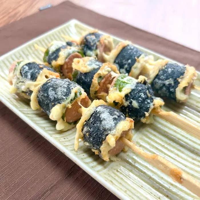 天ぷら風の海苔巻き刺しが串に刺さって、緑のトレーに綺麗に並べられています。