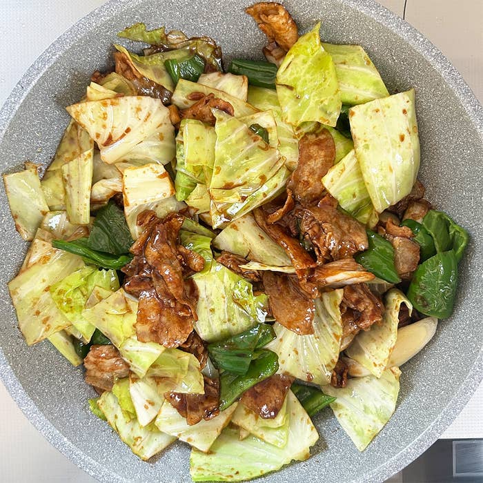 キャベツと肉の炒め物がフライパンに盛られている。