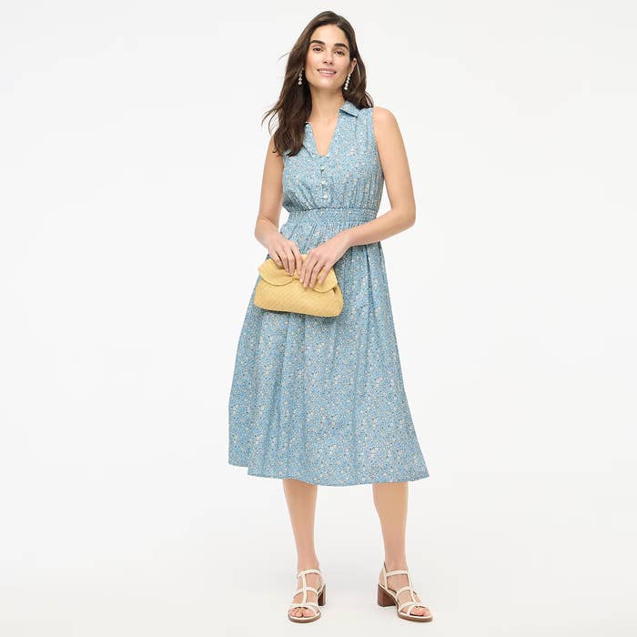 Social media trends Viral content Trending hashtags Social media updates Trending memes and videos Person in sleeveless floral dress holding a woven clutch and wearing strappy sandals, posing confidently