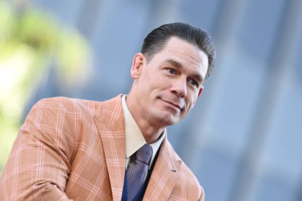 Person in a stylish plaid suit and tie, standing at a formal event