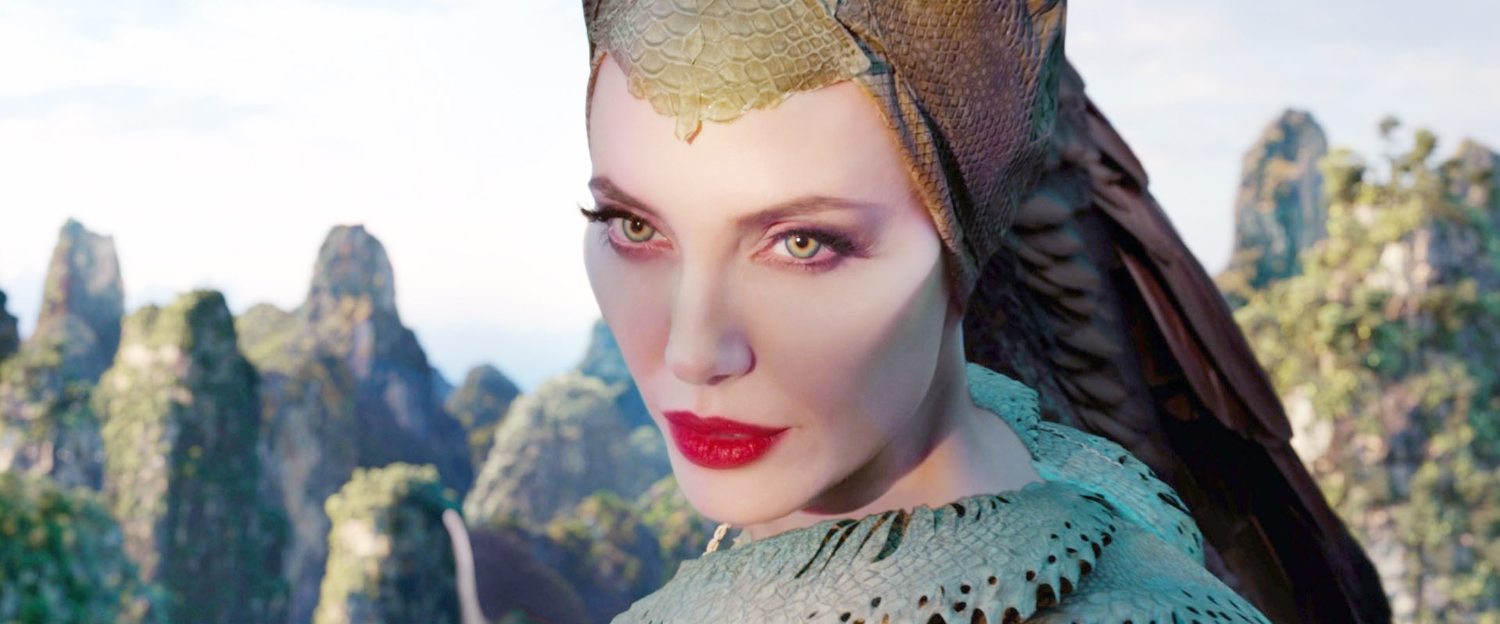 Fantasy character with elaborate headdress and scales, looking intently against a mountainous landscape