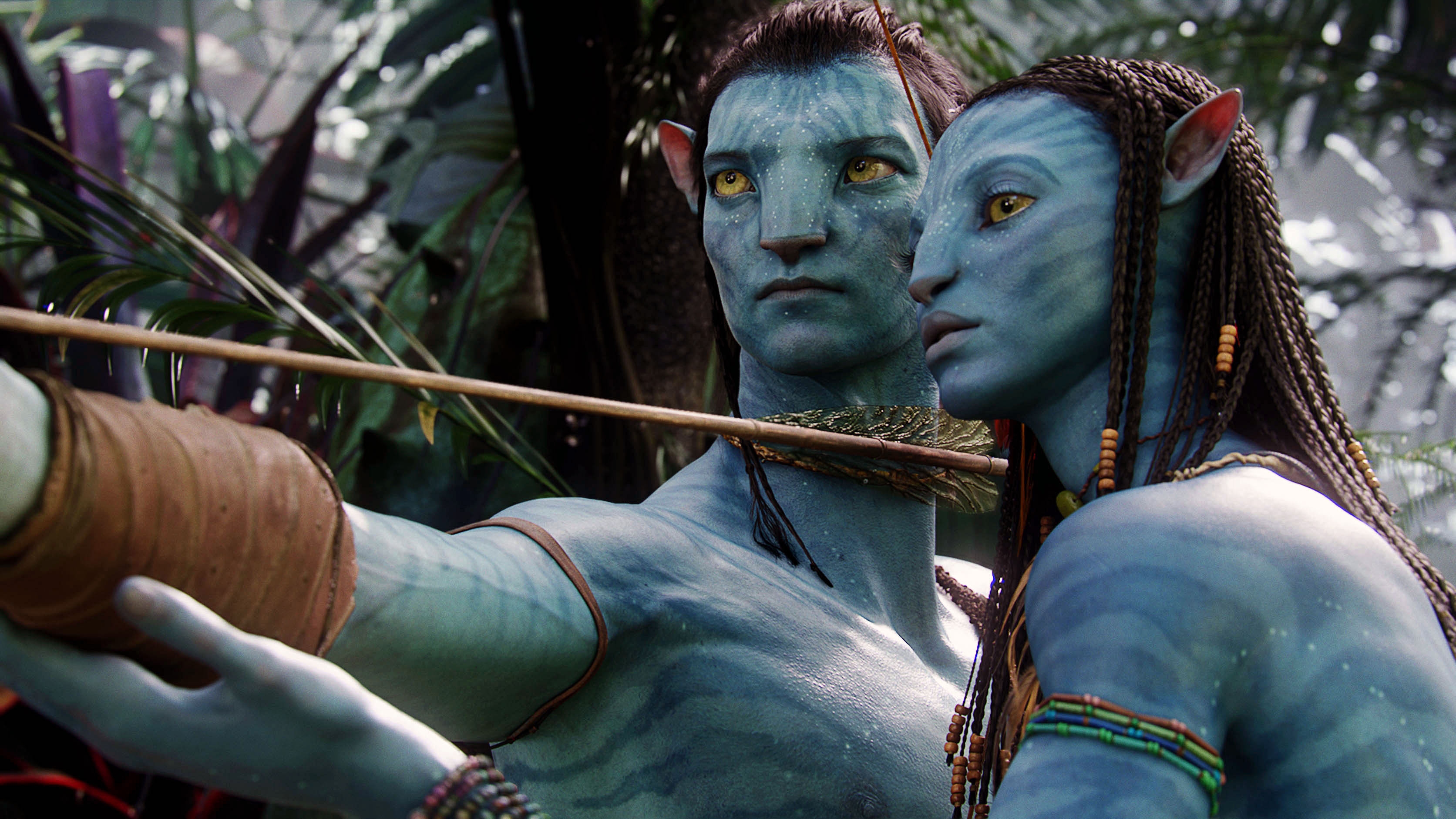 Two blue-skinned humanoid characters from a sci-fi movie, one drawing a bow, set in a lush alien forest