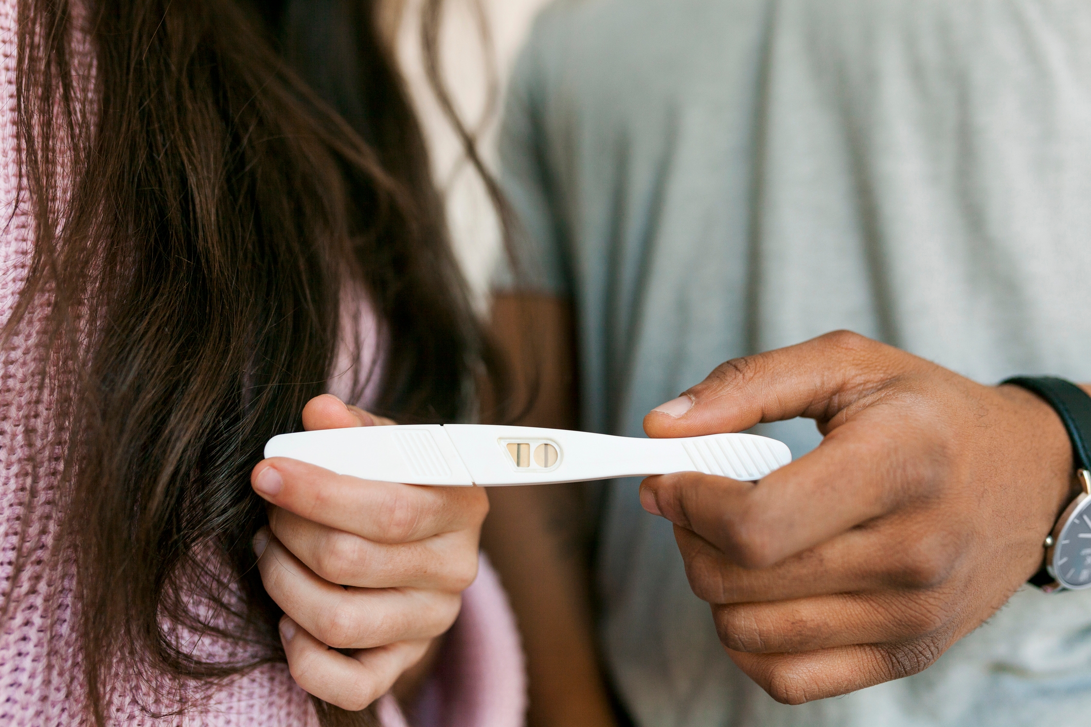 Two people holding a pregnancy test