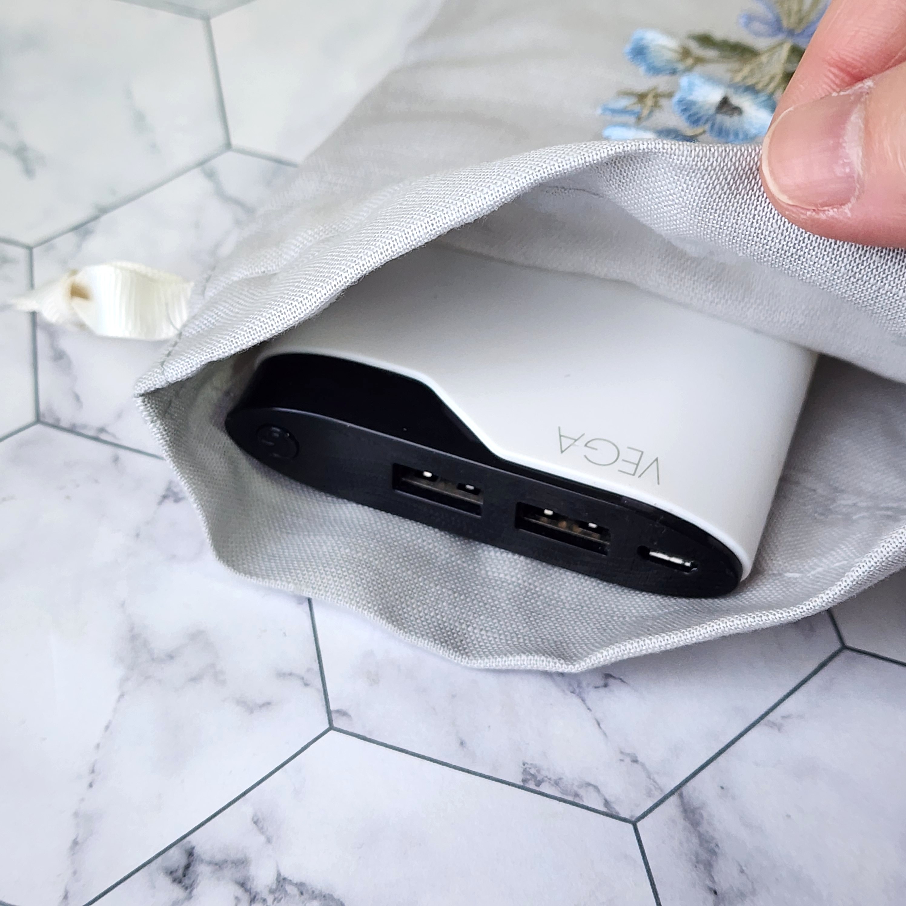 袋から見えるUSB充電器。穴のタイル上の表面に配置されています。