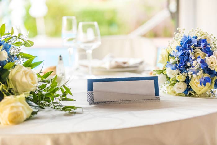 Elegant table setting with floral centerpieces and an empty name card, ready for a formal event or celebration