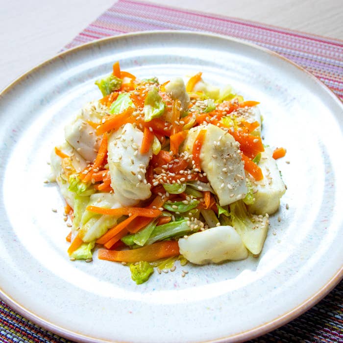 野菜とはんぺんが盛られた皿。にんじん、キャベツ、ゴマがトッピングされ、健康的な食事として運ばれている。