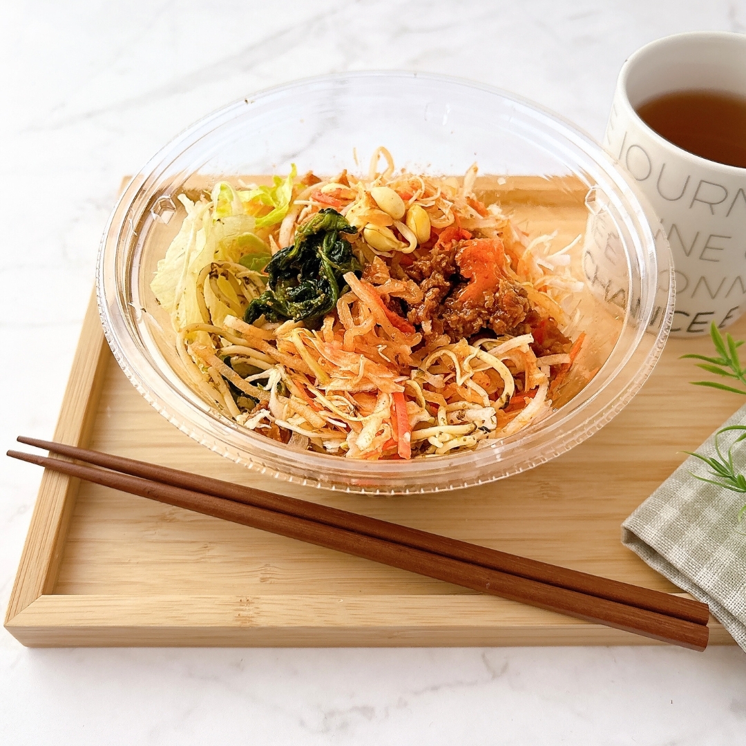 サラダとお茶のセットが木製トレーに載せられ、箸も添えられている。