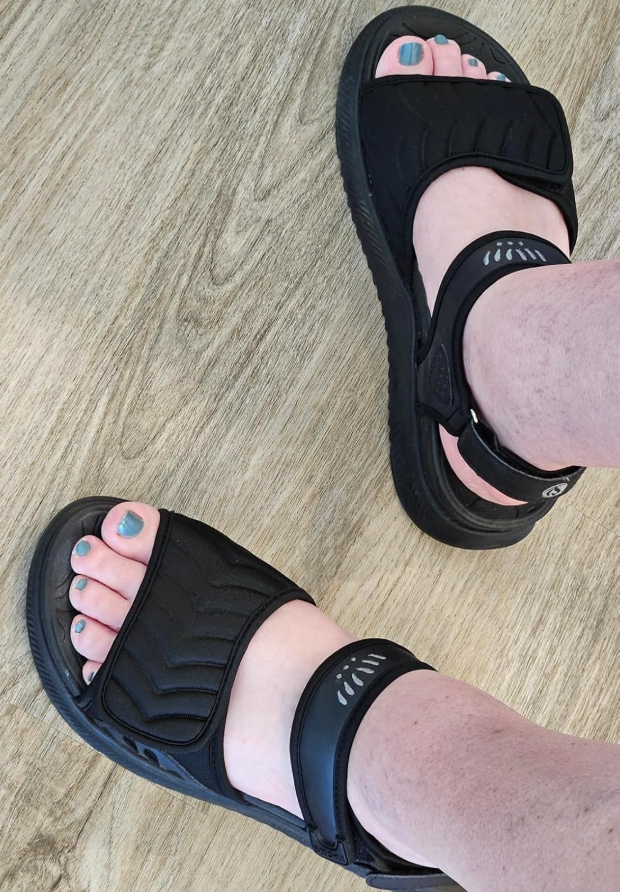 reviewer wearing comfy  achromatic  sandals