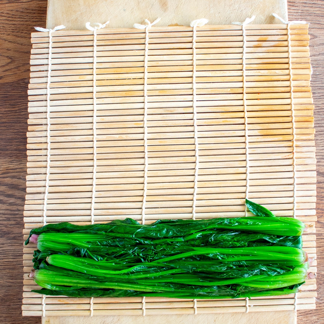 巻きすにのった湯通ししたほうれん草。