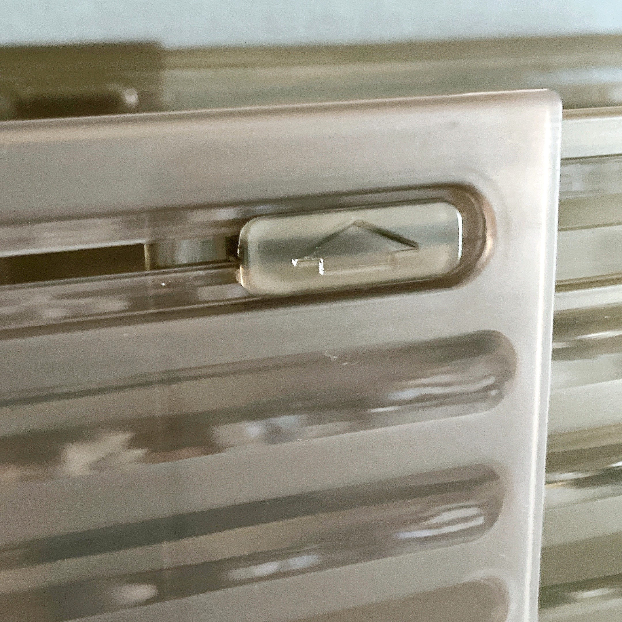 プラスチック製のスライドレバーがある収納ケースの一部が映っています。