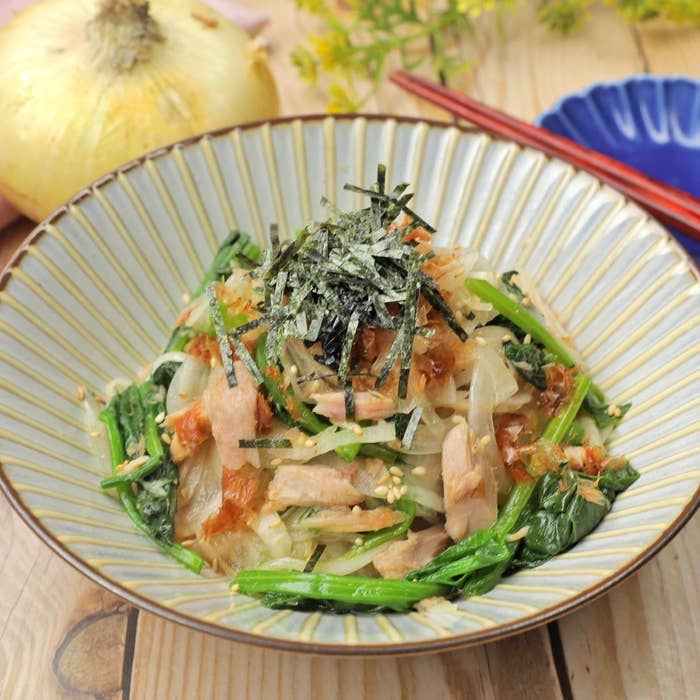 和風パスタ、ツナ、ほうれん草、玉ねぎ、海苔がトッピングされた美しい盛り付け。テーブルセッティングが素朴。