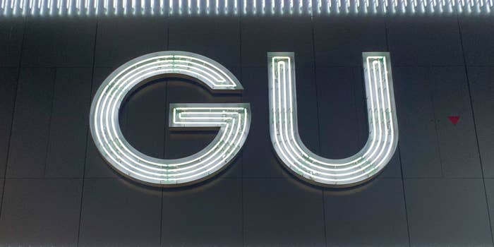 Neon sign displaying the letters &quot;GU&quot; on a dark background