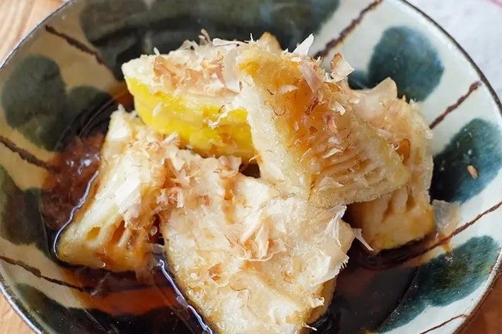 器に盛られた焼き物の皿に、割いた山芋が鰹節と醤油で和えられている料理。