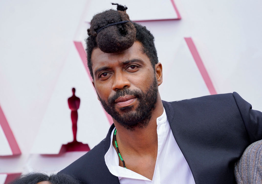 Person on the red carpet wearing a white shirt and a dark jacket, with unique hairstyle