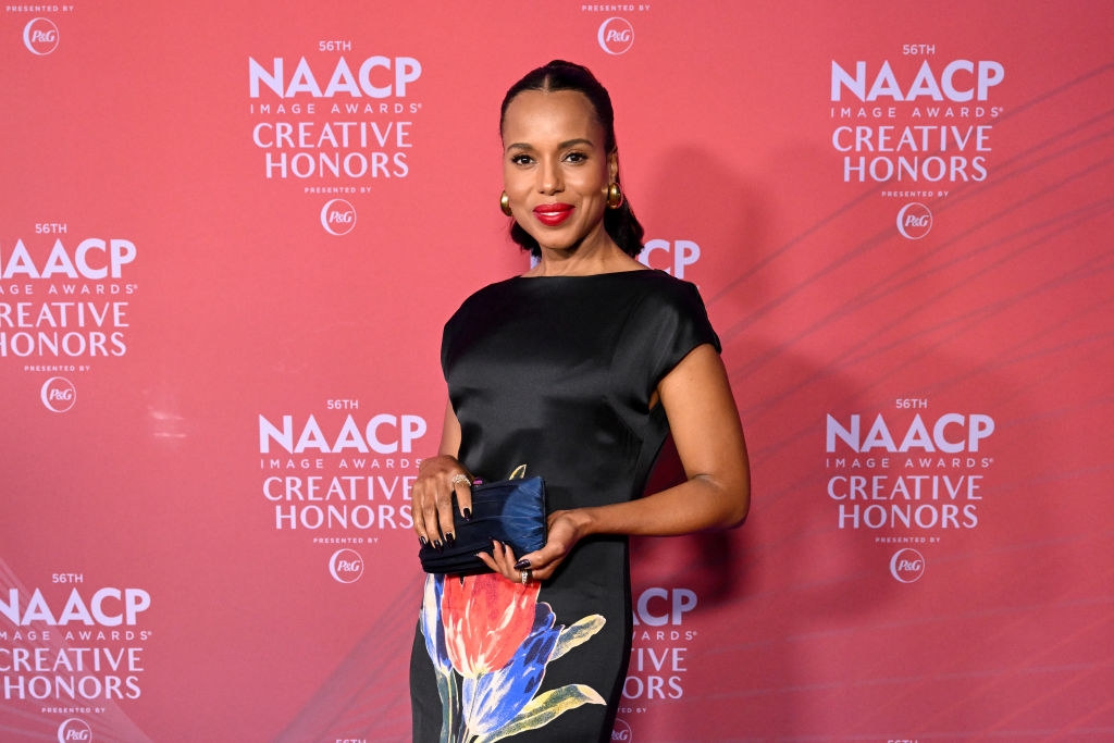 Person in elegant black dress with floral design, holding a clutch, at NAACP Image Awards Creative Honors event